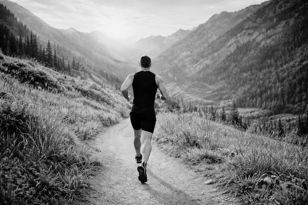 Person running on a mountain trail with scenic view